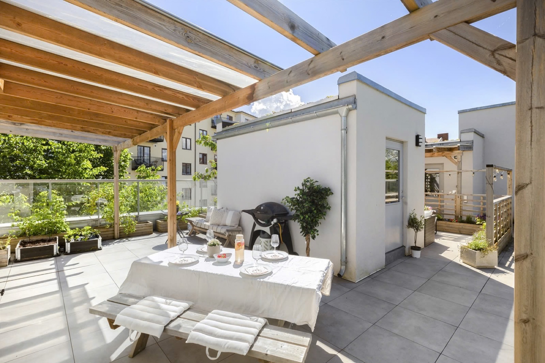 Sunny terrace with a pergola and a set dining table