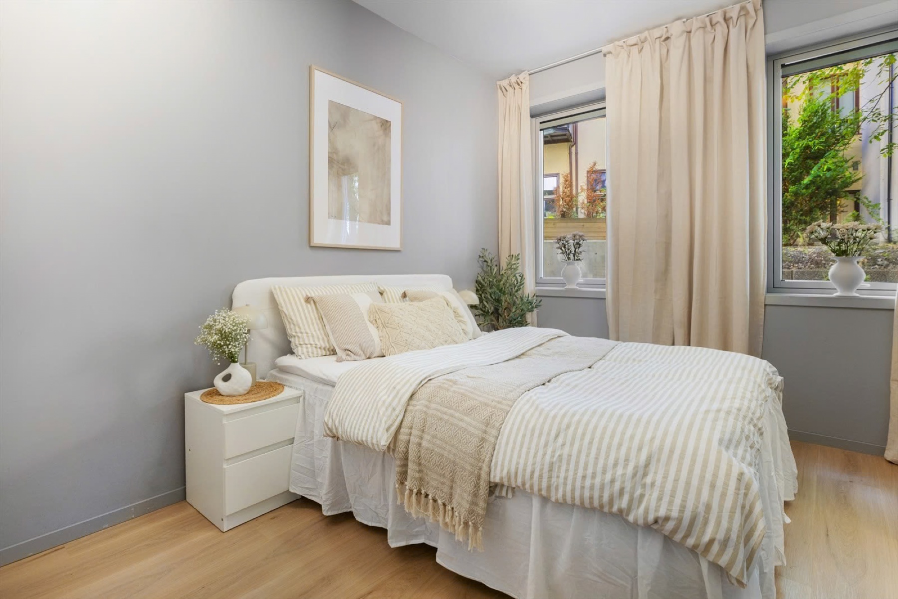 Bright bedroom with soft textiles and leafy views