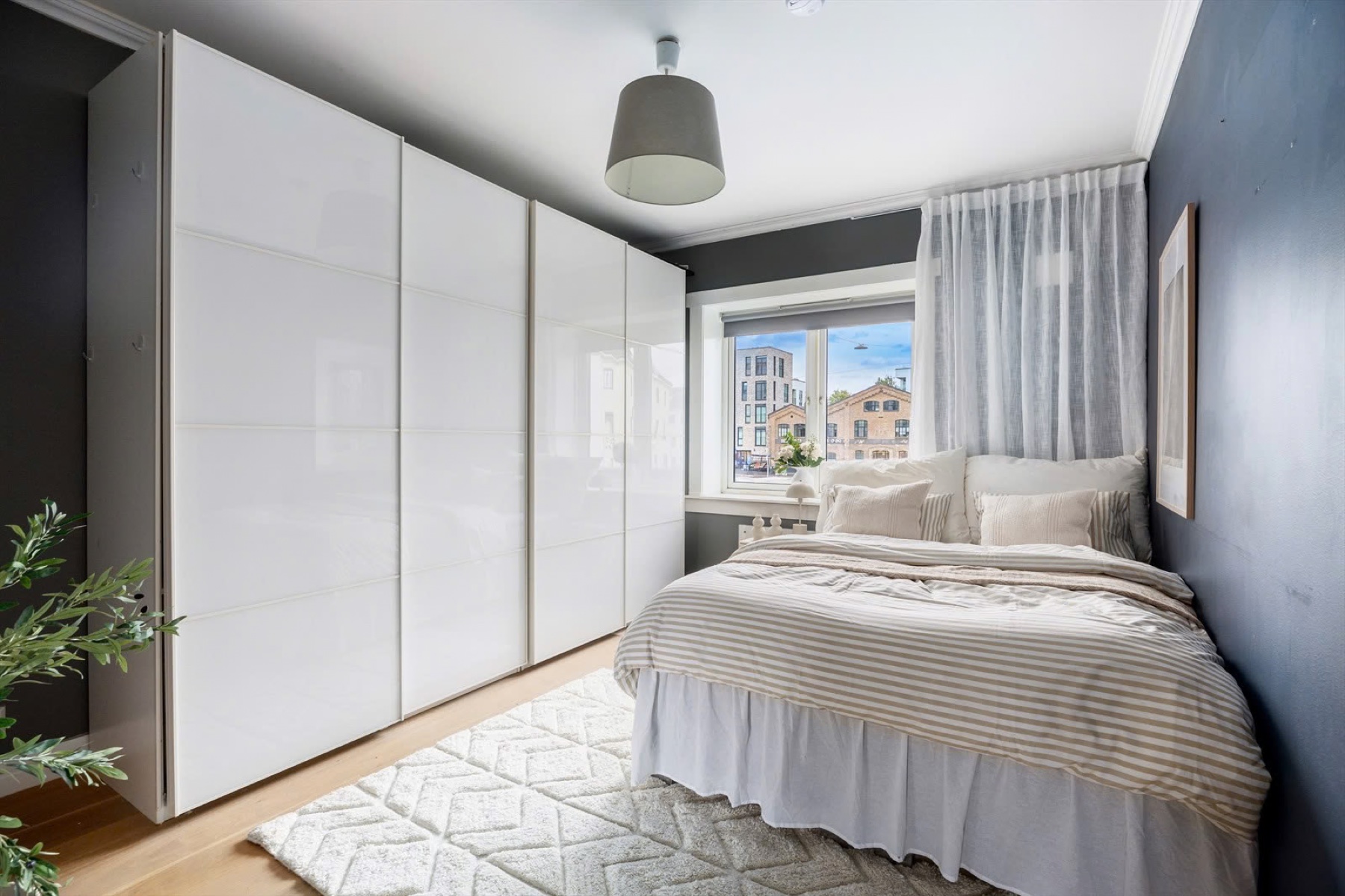 Bedroom with blue walls, mirrored wardrobes and light bedding